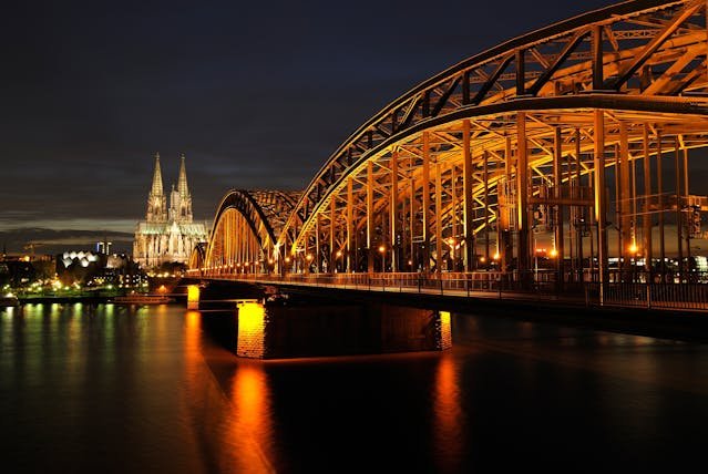 Hohenzollern Bridge iluminado en Colonia sobre el río por la noche