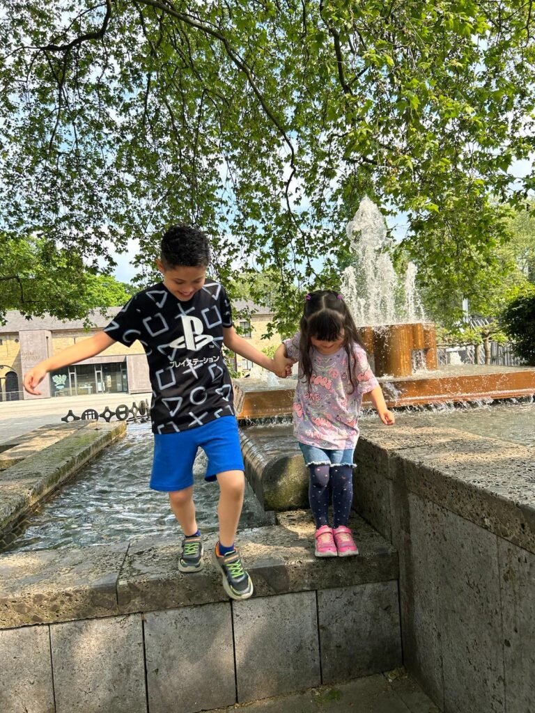 Carol - con mi familia disfrutando de un paseo en Alemania, con mis hijos jugando cerca de una fuente.
Mudarse a Alemania con hijos